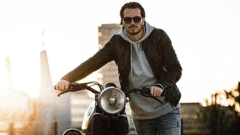 man walking with a motorcycle