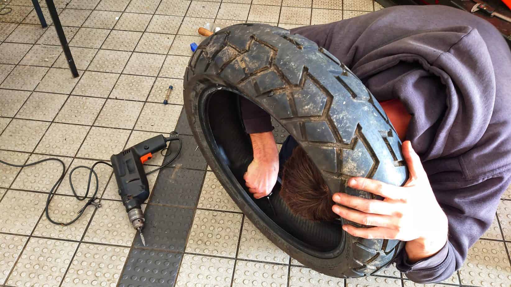 Man fixing motorcycle tire, puncher repair on motorcycle tire, motorcycle tire, Dunlop off-road tire