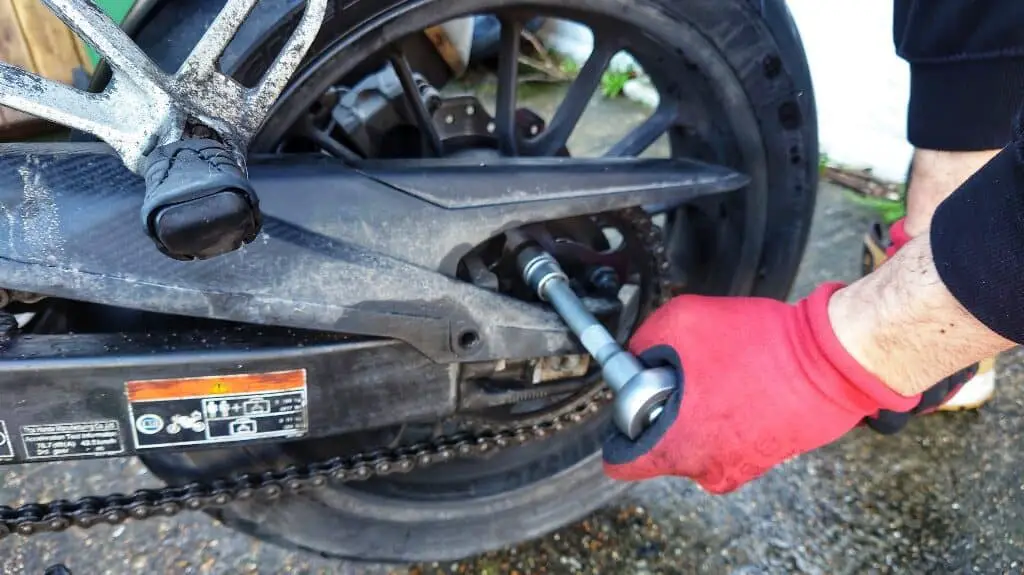 Loosening the rear sprocket retaining nuts with a ratchet